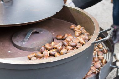 Eski demir tavalarda geleneksel ateş üzerine kavrulmuş kestane 