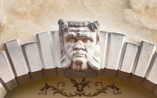 Devil head carved above the stone arch of an Italian villa. — Stock Photo, Image