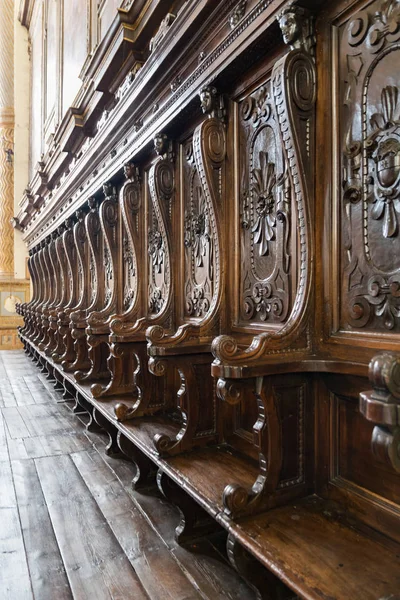 Detalles de bancos de madera junto al altar de una iglesia medieval . — Foto de Stock