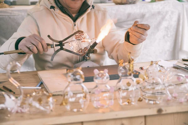 Handwerker dekoriert Glasobjekte mit einer Fackel. — Stockfoto