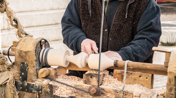 Een ambachtelijke kerft een stuk hout met behulp van een handmatige draaibank. — Stockfoto