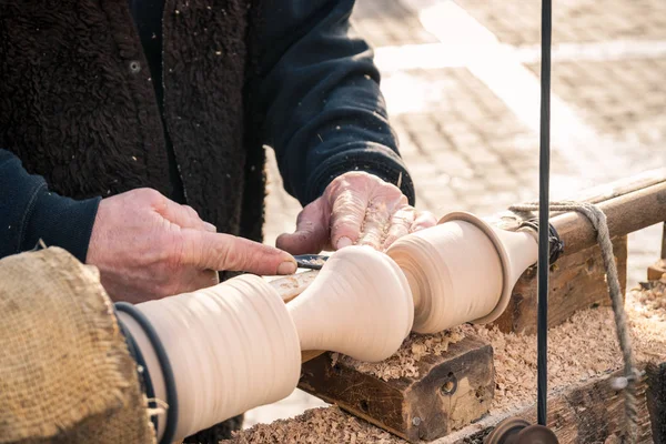 Ein Handwerker schnitzt ein Stück Holz mit einer Handdrehbank. — Stockfoto