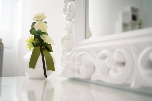 Elegante tarro de rosas amarillas con muebles blancos . — Foto de Stock