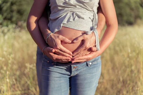 Pareja esperando a un niño y abrazándose con su han —  Fotos de Stock