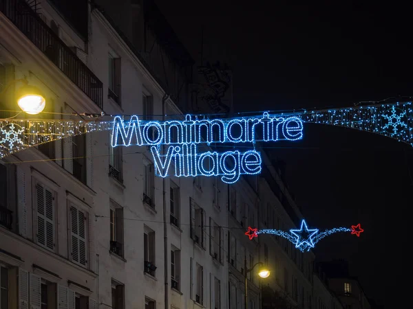 Illuminated sign with the words "Montmartre Village" placed at t — Stock Photo, Image