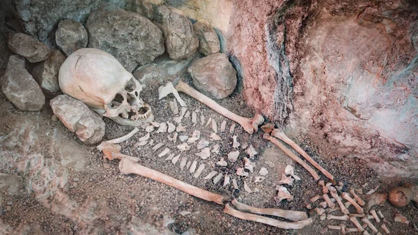 Skeleton of a primitive man inside a cave.