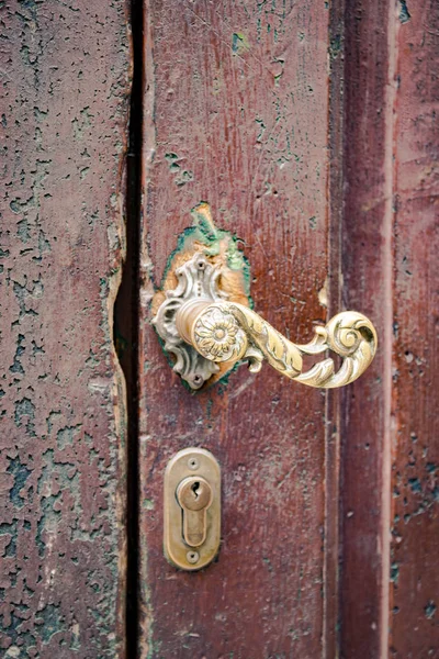 Az aranyozott fém fogantyú, egy régi fából készült ajtó részlete. — Stock Fotó