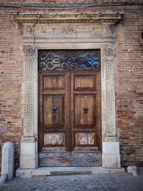 Sütunlar ve arşitrav beyaz taş ile eski ahşap portal.