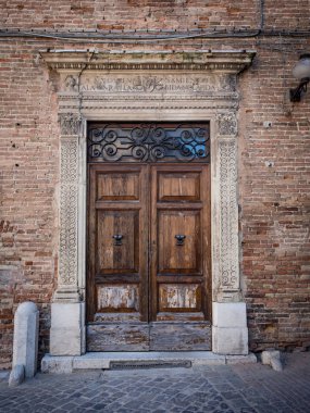 Sütunlar ve arşitrav beyaz taş ile eski ahşap portal.