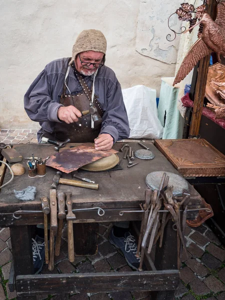 Detalle de un artesano graba una placa de cobre con un martillo y —  Fotos de Stock