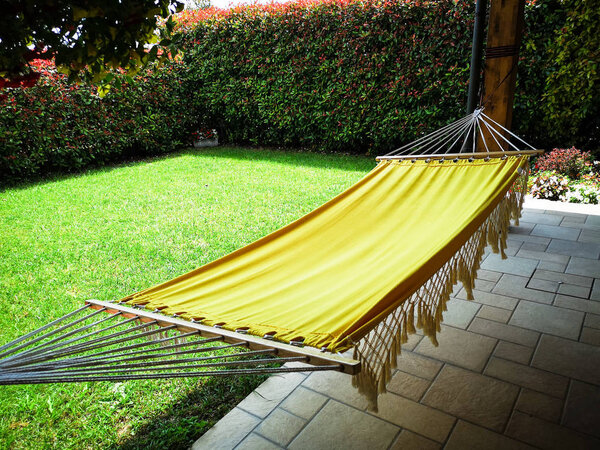 Yellow hammock in the garden of a house.