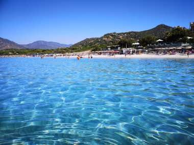 Villasimius, İtalya - 10 Ağustos 2019: Mavi ve şeffaf su ve Sardunya 'da bir kumsalın hafif kumu.
