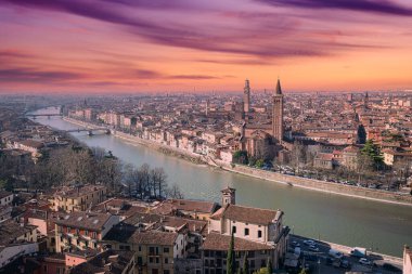 Verona 'nın tarihi merkezinin panoramik manzarası gün batımında Adige nehrinin yanından geçti..
