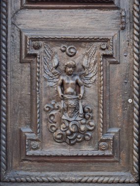 Eski bir İtalyan kilisesinin ahşap kapısına oyulmuş bir meleğin ayrıntıları..