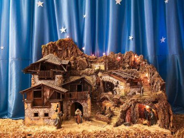 Ossana, İtalya - 26 Aralık 2019: El yapımı beşik doğum sahnesi. Arka planda yıldızlı ipek gökyüzünde.