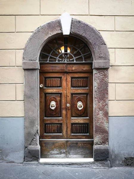 Ancient and solid wooden door with imposing stone arch.