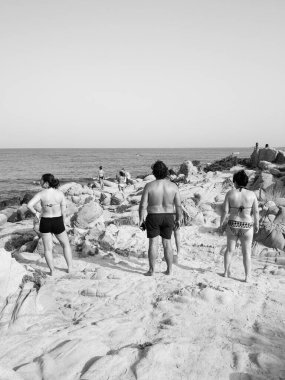 Sardunya, İtalya - 7 Ağustos 2019: Sardunya 'nın tipik kum ve kaya plajlarında turistler ve banyolar.