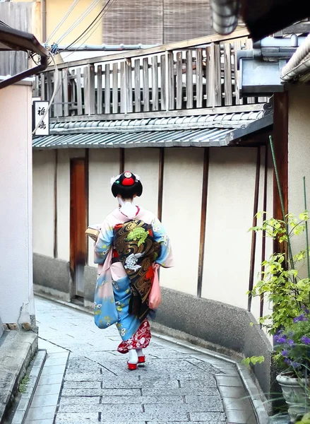 Uma maiko andando pelas ruas do bairro Gion à tarde à procura de uma casa de chá, Kyoto, Japão — Fotografia de Stock