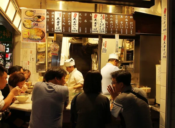 Tokyo, Japonia - 2 august 2017: Localnicii se amestecă cu câțiva turiști care iau cina în strada Shinjuku Yakitori Yokocho, o mică stradă ascunsă care se găsește în mijlocul districtului de afaceri Shinjuku — Fotografie, imagine de stoc