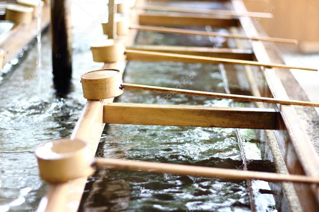 Detail of a typical Temizuya (a Shinto water ablution pavilion for a ceremonial purification rite known as temizu) placed in one of the entrances of Meiji-Jingu temple in Shibuya neighborhood, Tokyo.