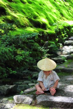 Küçük bebek özel bir geleneksel yukata giymiş orman yaprakları ile oturma sırasında Jojakko-ji Tapınağı'nın ana giriş merdivenleri, Kyoto taş basamaklar üzerinde çalış.
