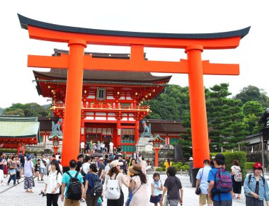Kyoto, Japonya - 10 Ağustos, 2017: Ana giriş yakın Fushimi Inari Taisha tapınak içinde. Inari dağ Base'deki yer daha küçük toriis yüzlerce çok sayıda turist yürümek zirveye kadar yollar içerir.