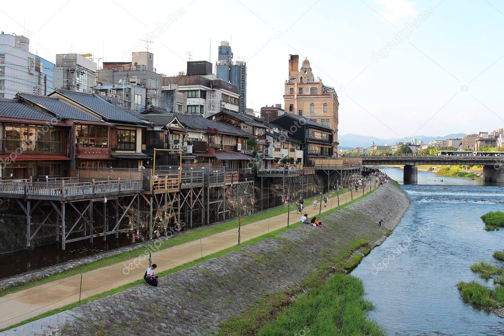 Main view of Kamo river promenade with many terraces of restaurants and bars with Kyoto's old town buildings on background, Gion, Kyoto, Japan.