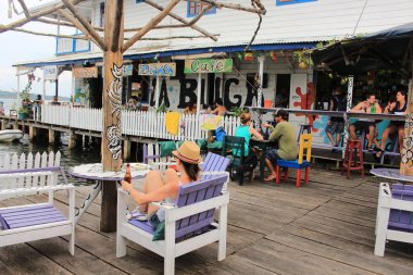 Bocas del Toro, Panama - 10 Ağustos 2014: turist ve gezginler sörf, Dalış ve güneş plaj alma uzun bir günün ardından Bocas del Toro şehir waterfront Bar ve Teras bir içeceğin tadını