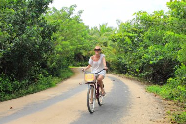 Genç güzel turistik Panama Bocas del Toro adaların kum yollarında bisiklet sürmek.