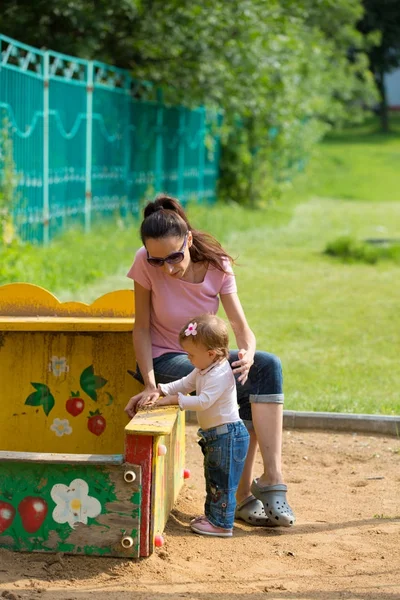 Moeder en baby spelen op de speelplaats — Stockfoto