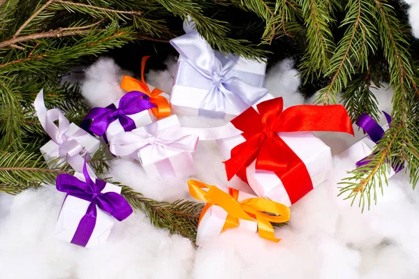 Un ensemble de cadeaux de Noël sous des branches de sapin sur fond blanc — Photo