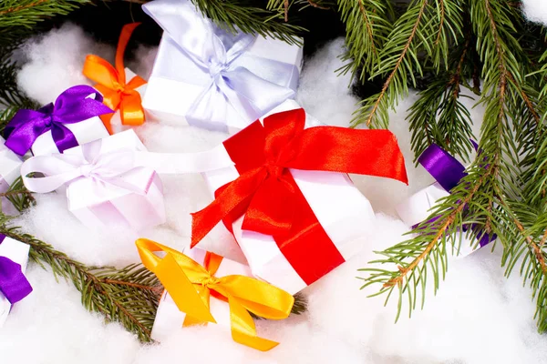 Un ensemble de cadeaux de Noël sous des branches de sapin sur fond blanc — Photo