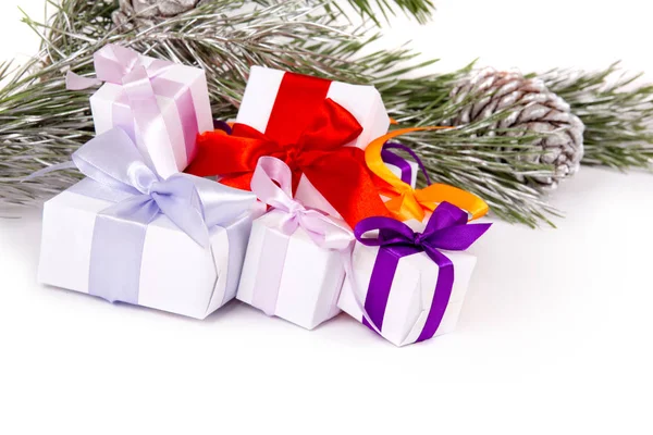 Ein Satz Weihnachtsgeschenke unter Tannenzweigen auf weißem Hintergrund — Stockfoto