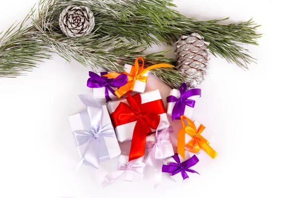 Un ensemble de cadeaux de Noël sous des branches de sapin sur fond blanc — Photo