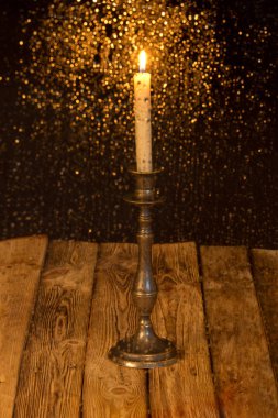 Yanan bir mum arka plan üzerinde bulanık cam su damlaları