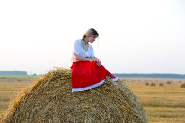 Güzel kız geleneksel kostümlü hububat sahada yürüyor