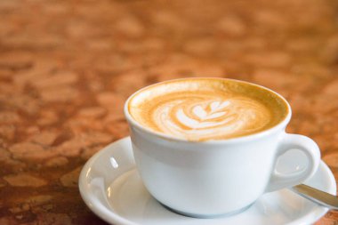 Fincan cappuccino bir tablo. Sıcak kahve cappuccino latte sanat beyaz seramik Kupası'nda en iyi görünümü ahşap tablo