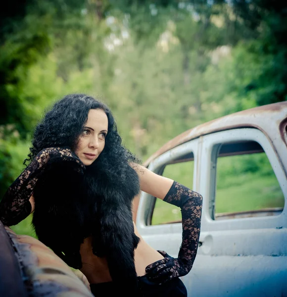 Güzel genç kız eski kırık araba yakınındaki lüks kürk yakalı — Stok fotoğraf