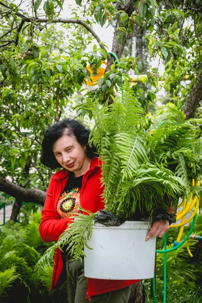 De tuinman van de vrouw in de groene lentetuin. Werk van de lente in de tuin — Stockfoto