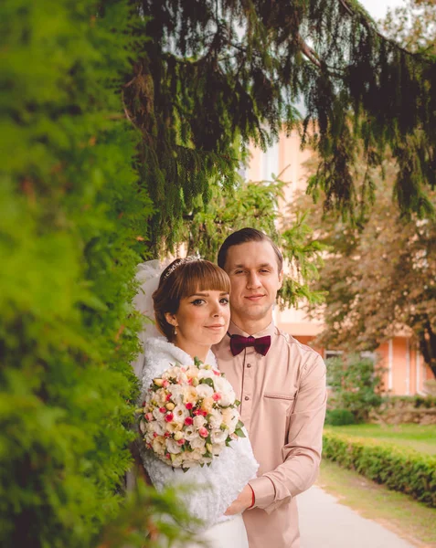 Jonge mooie bruid en bruidegom in herfst park. Familie portret — Stockfoto