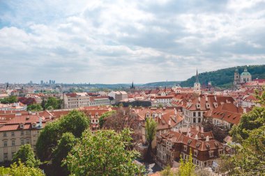 Prag bahar. Kırmızı ile eski evlerin çatı ve parlak yeşil yeşillik döşeme. Tarihi