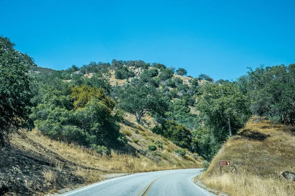 Viaje de férias nos EUA. Uma estrada sinuosa no pitoresco Sequoia Park, Califórnia — Fotografia de Stock