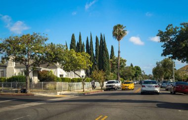 Los Angeles, Kaliforniya, ABD - 21 Mart 2017: Avuç içi ve Los Angeles sokaklarında. Melrose şehir yaşamında. Yeşil çimenler, tropikal palmiye ağaçları ve araçların yolda. Rahat konut çeyrek