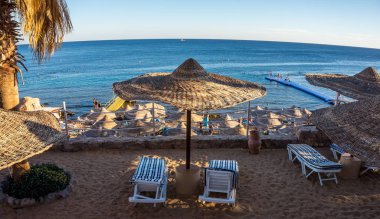 Plaj ve plaj şemsiye. Sharm el-Sheikh Kızıldeniz kıyısında. Denizin kenarında aile tatili
