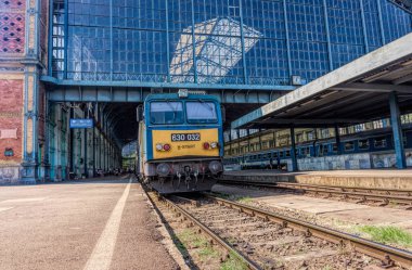 Budapeşte, Macaristan - 29 Ağustos 2019: Budapeşte, Macaristan 'daki eski Nyugati Palyaudvar tren istasyonu ve yolcu vagonları platformu. Avrupa 'da demiryolu toplu taşımacılığı. Eski bina ve istasyon binasında turistler