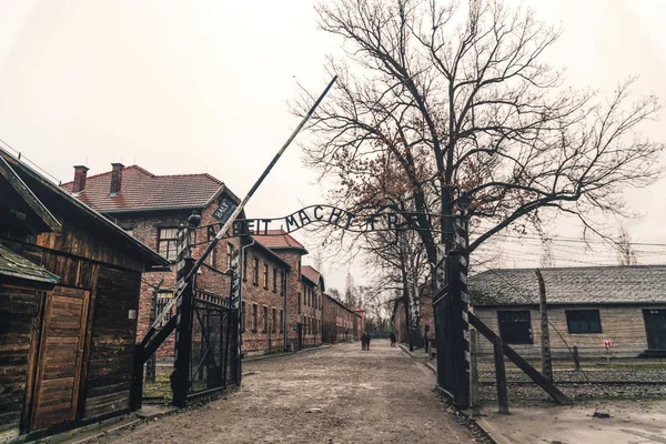 Auschwitz, Poland - November 29, 2019: Concentration labor camp and Auschwitz-Birkenau death camp in Poland. Memorial and Museum of Nazi Terror and the Holocaust in Europe during World War II. Entrance to the camp and prison barracks. Historical Gate