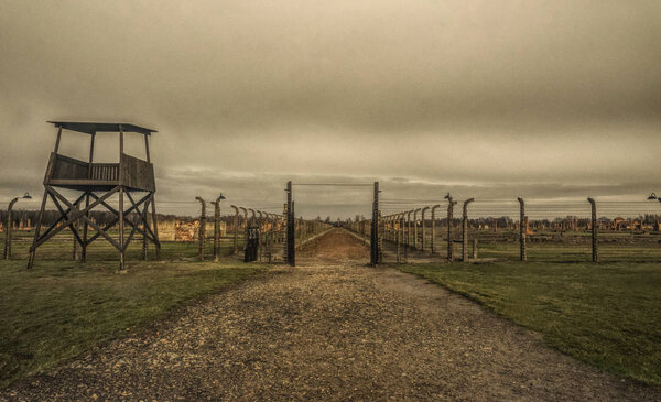 Auschwitz, Poland - November 29, 2019: Concentration labor camp and Auschwitz-Birkenau death camp in Poland. Memorial and Museum of Nazi Terror and the Holocaust in Europe during World War II. Entrance to the camp and prison barracks