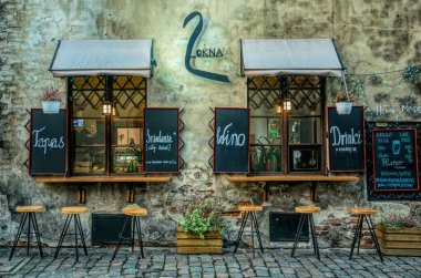 Krakow / Polonya - 30 Kasım 2019: Krakow, Polonya 'daki Kazimierz' in eski Yahudi mahallesinde kaldırımda bulunan kafe. Geleneksel Polonya ve Yahudi mutfağı. Turistler tarihi caddelerde yürüyor 
