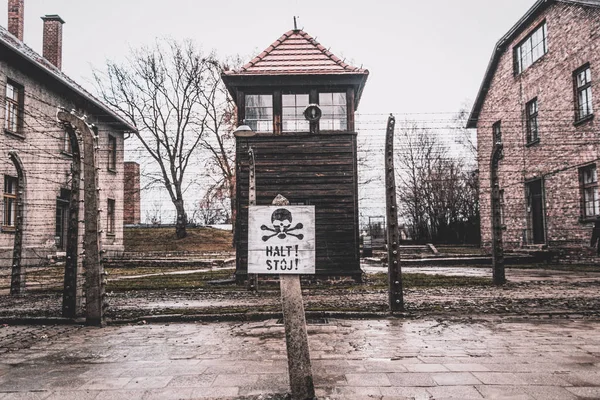 Auschwitz, Poland - November 29, 2019: Hazard warning street sign - skull and crossbones. Barbed wire and live wires in the Nazi concentration camp Auschwitz in Poland. Memorial and Museum of Nazi Terror and the Holocaust in Europe