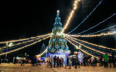 Kremenchuk / Ukrayna - 30 Aralık 2019: Kutlama Noel ağacı ve Ukrayna 'nın Kremenchug kentindeki Noel pazarında eğlenen insanlar. Yeni yıl beklentisi içindeki insanlar.